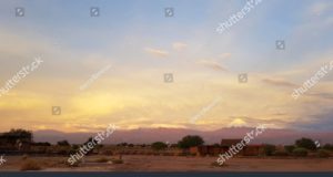 Las luces del atardecer en el paisaje árido y desolado del desierto de Atacama con los picos de los volcanes nevados de la cordillera de los Andes en el fondo. Autor y Copyright Marco Ramerini